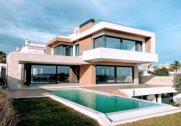 White contemporary home with a large front lawn