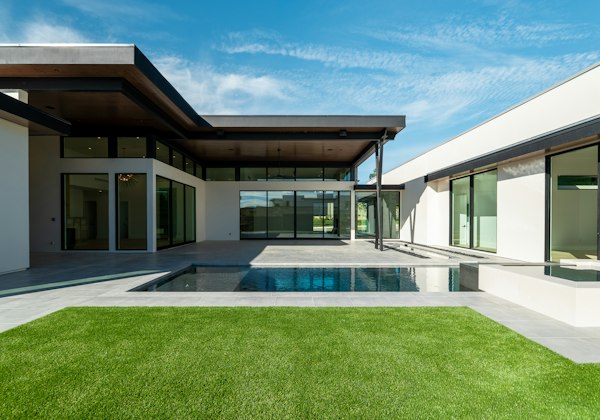 Modern home with a swimming pool and green lawn